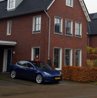 Huis met zonnepanelen en elektrische auto op de oprit