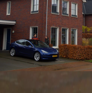 Huis met zonnepanelen en elektrische auto op de oprit