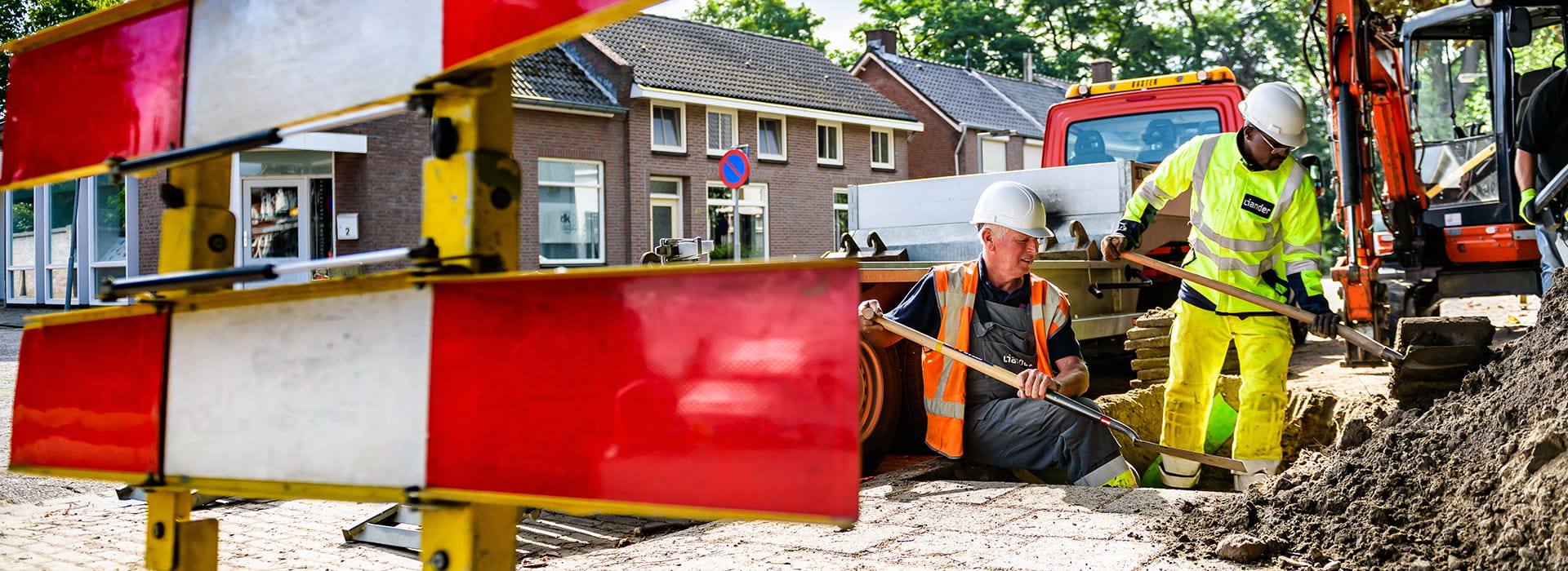 twee monteurs van Liander bij graafwerkzaamheden in de straat