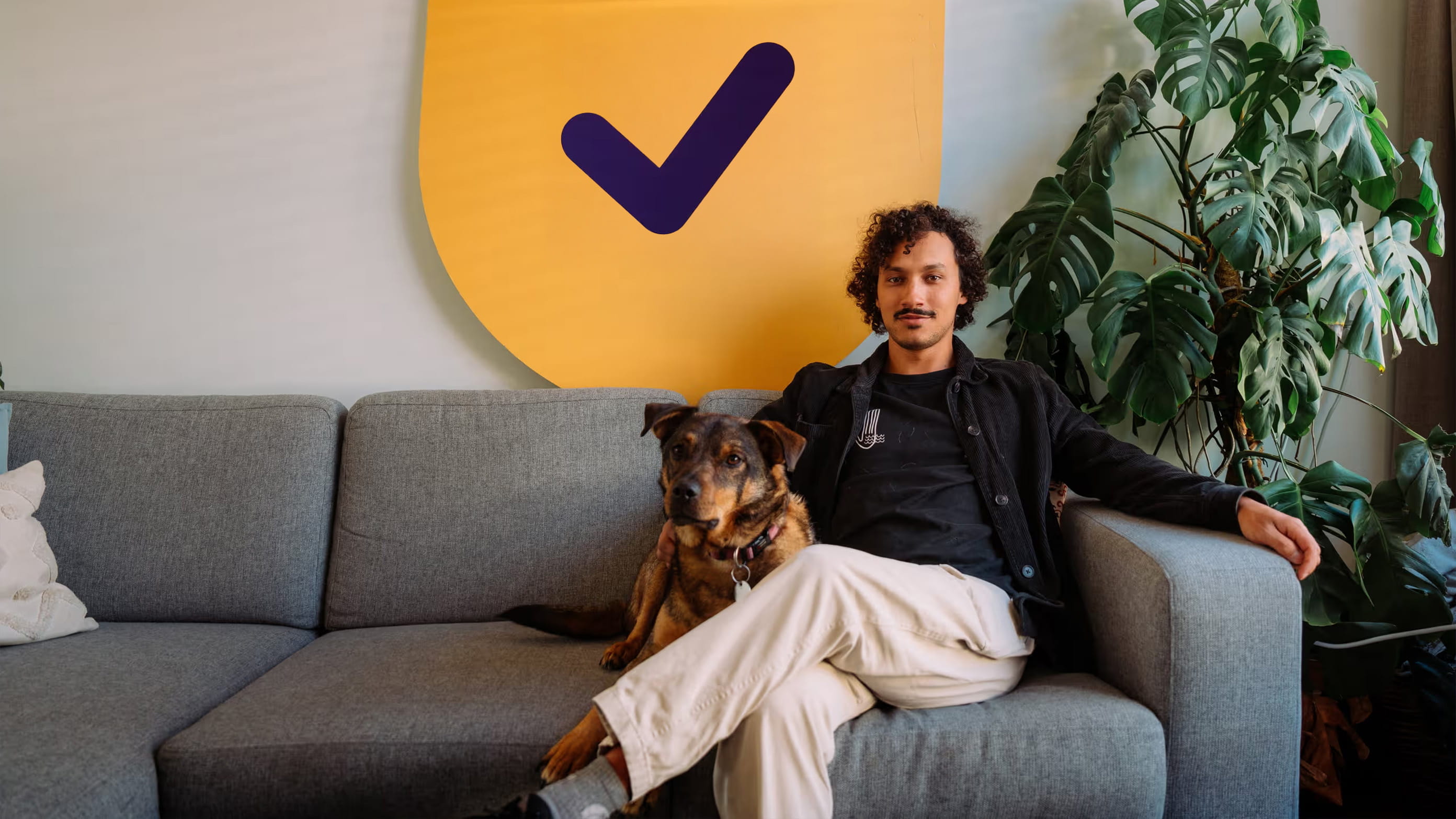 Man zit met hond op de bank en kijkt tevreden en voorbereid 