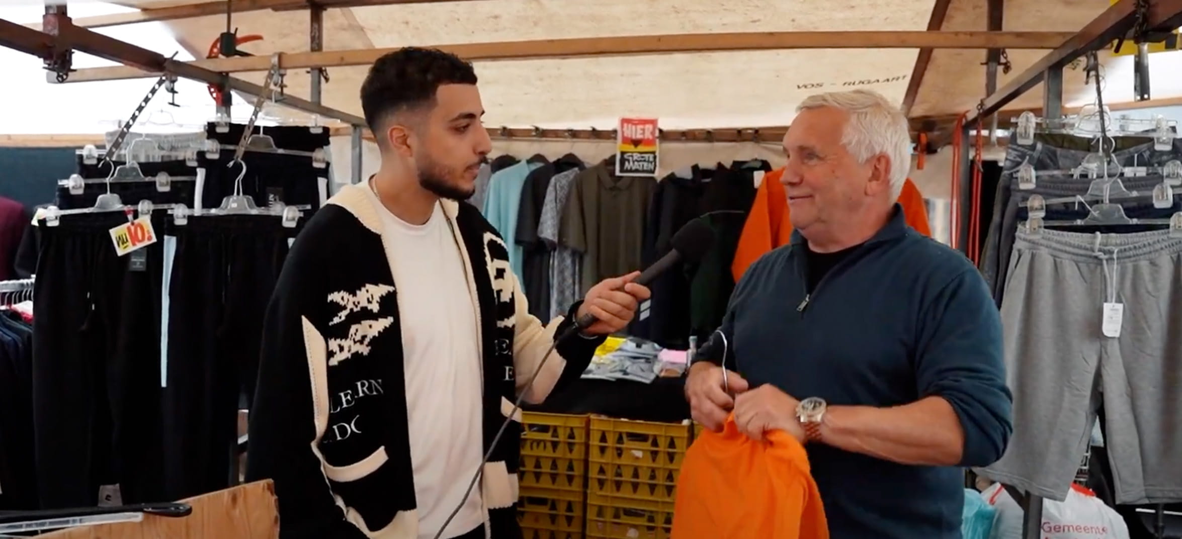 Oudere man geeft antwoord tijdens een straatinterview op de markt.