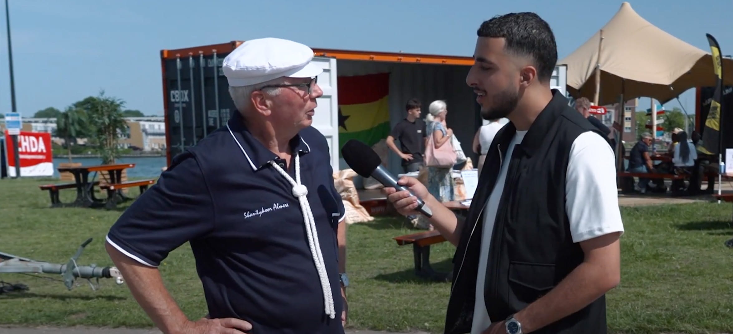Een man interviuewt een oudere man voor Straatvragen op de Zeehavendagen