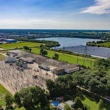 Luchtfoto van elektriciteitsstation Oudehaske met drijvend zonnepark van Groenleven ernaast