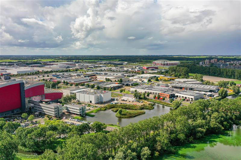 Luchtfoto van een bedrijventerrein met bedrijfspanden, waterpartijen en groen.
