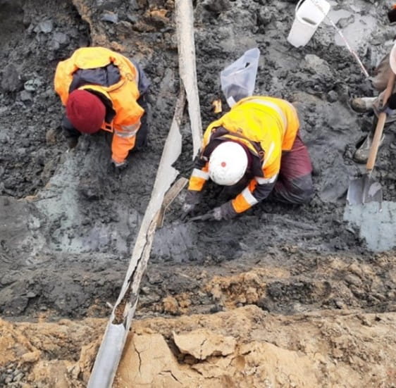 twee personen zoeken in de grond bij Katwijk naar archeologische vondsten