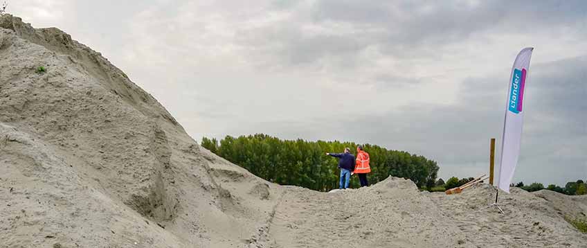 Liandevlag in zand met twee personen die kijken naar de zandberg