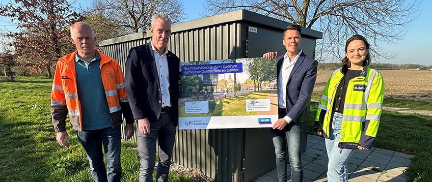 Medewerkers Liander en gemeente Doetinchem voor een elektriciteitshuisje met een bord voor de ondertekening