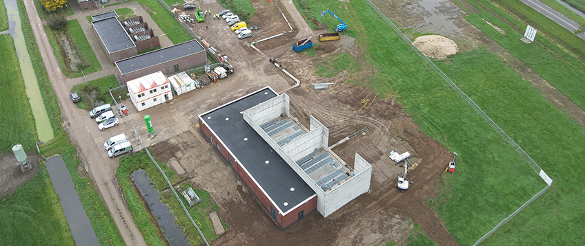 Bovenaanzicht van elektriciteitsstation Zuilichem, omringd door grasvelden en gelegen in een open, landelijke omgeving.