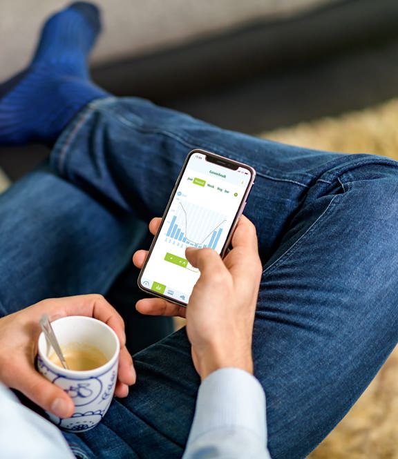 Man kijkt naar telefoon met energieverbruiksmanager