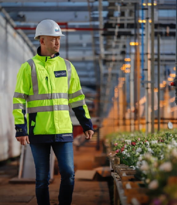 Medewerker van Liander loopt in bloemenkas