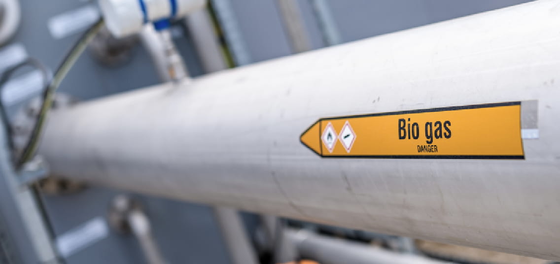 Afbeelding van biogasleiding. Witte pijp met een gele sticker met de tekst Bio gas erop.