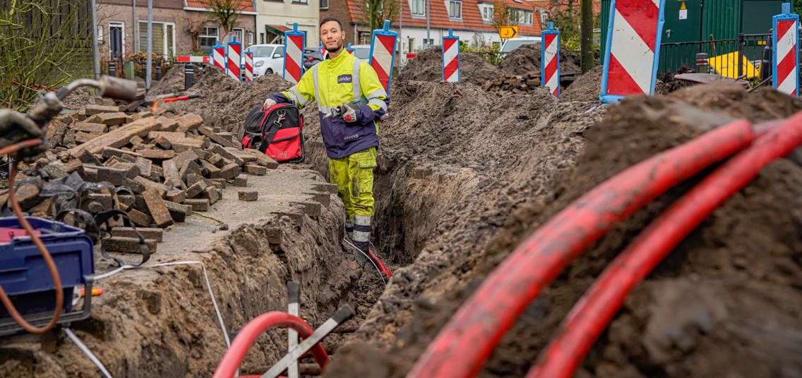 Man met lianderkleding aan het werk aan het net